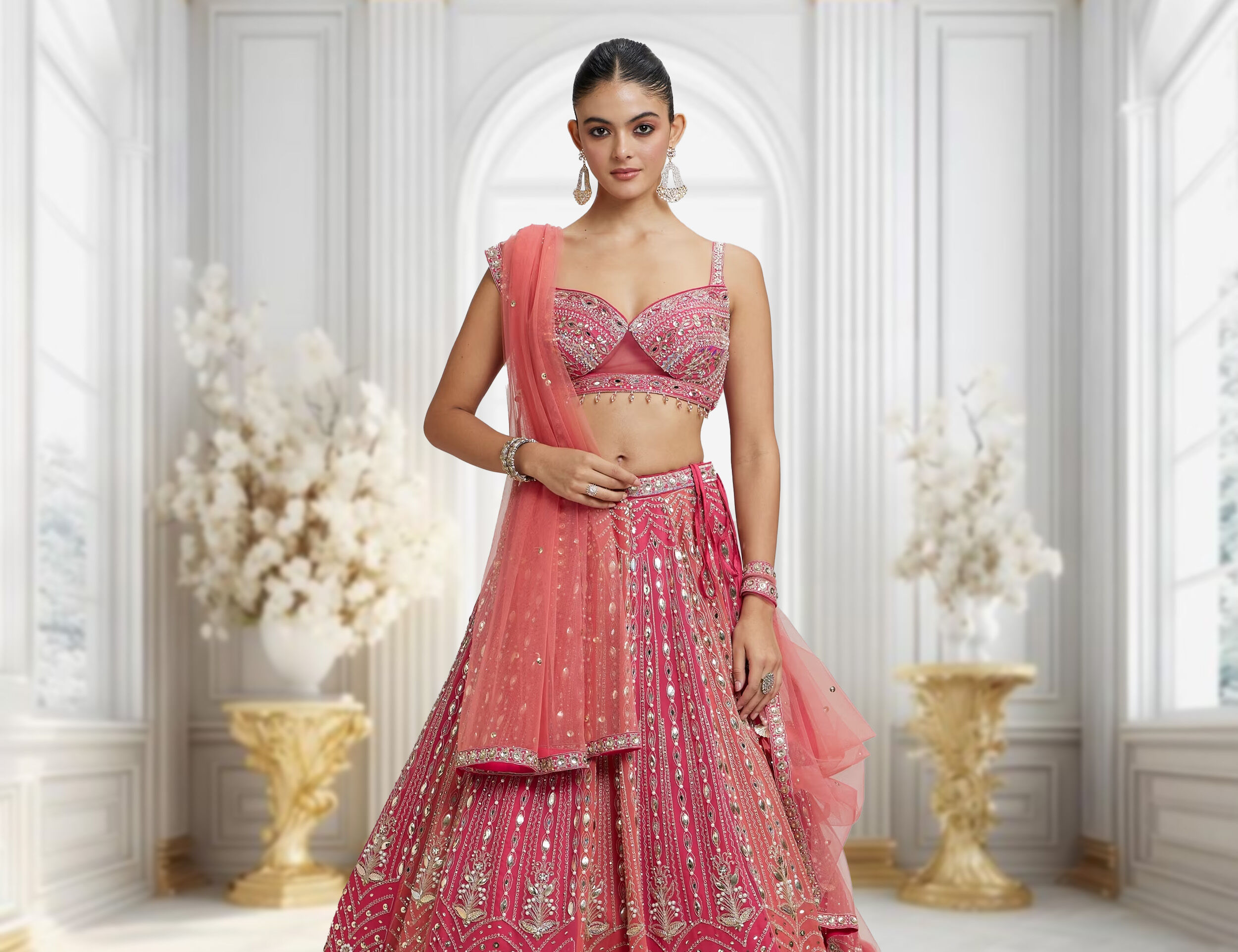 A woman in a brightly colored pink lehenga with intricate sequin work and a stylish blouse.